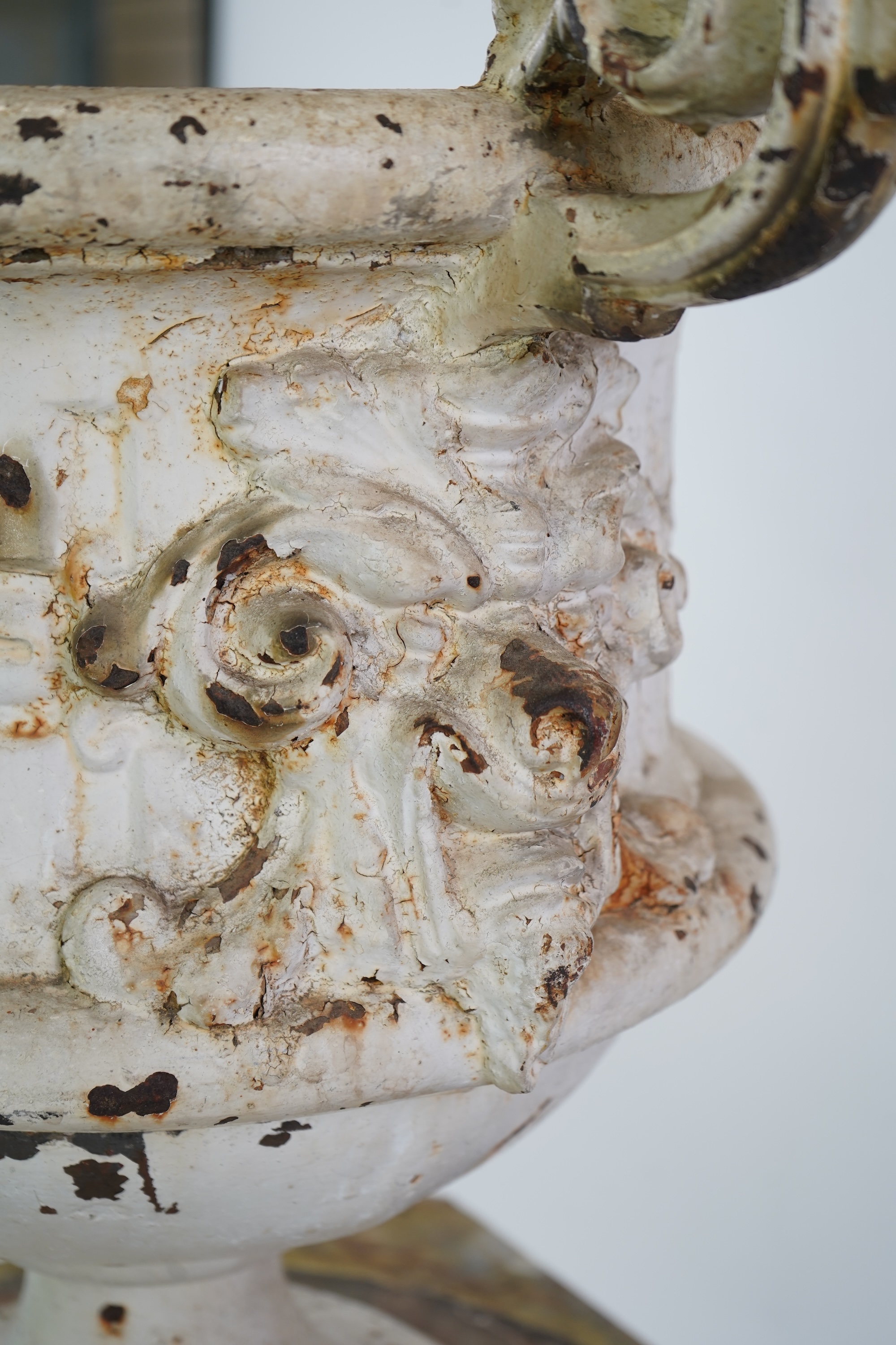 A Victorian white painted cast iron urn and a painted faux marble pedestal